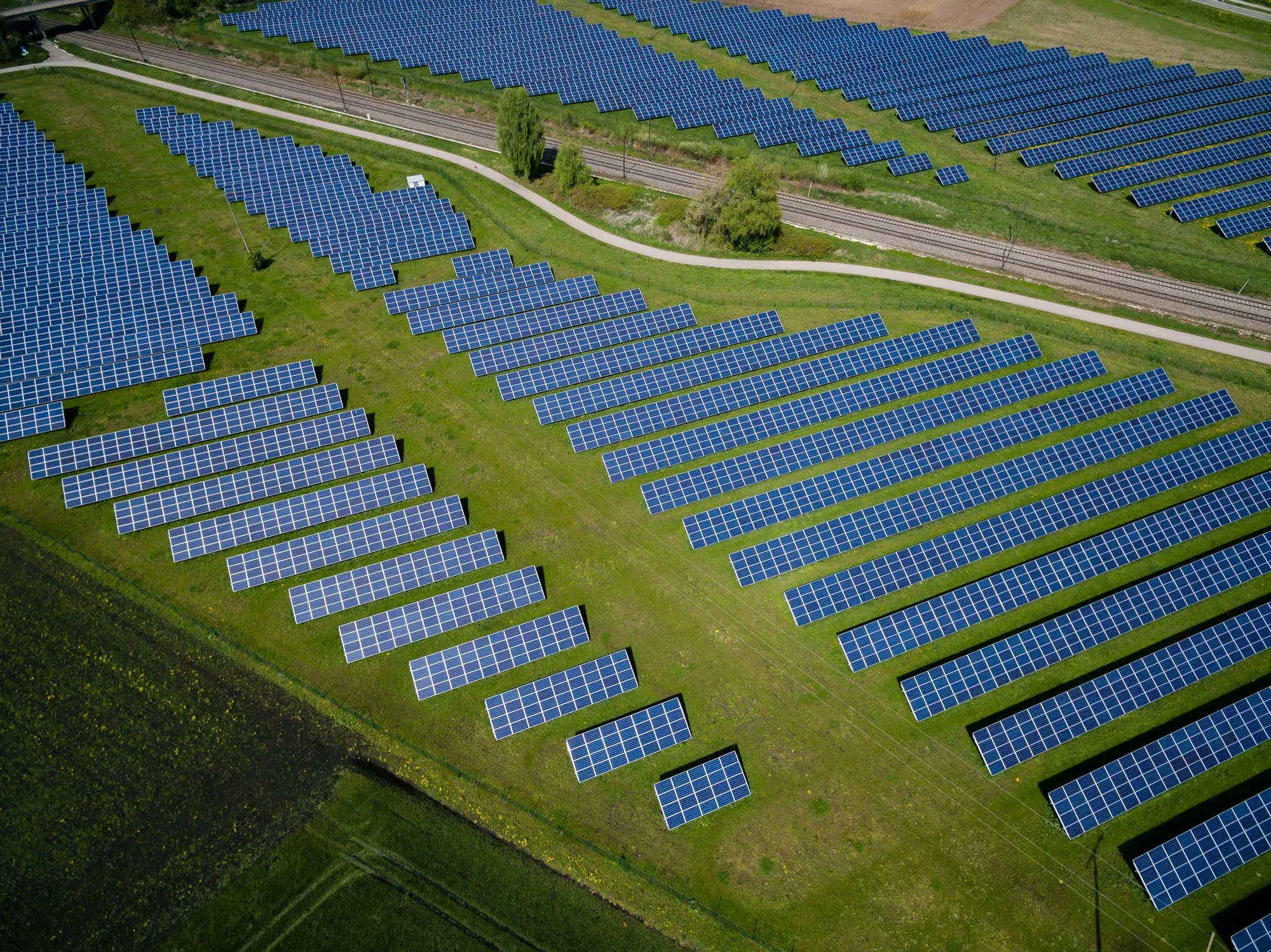 Aerial view of a solar field with rows of panels