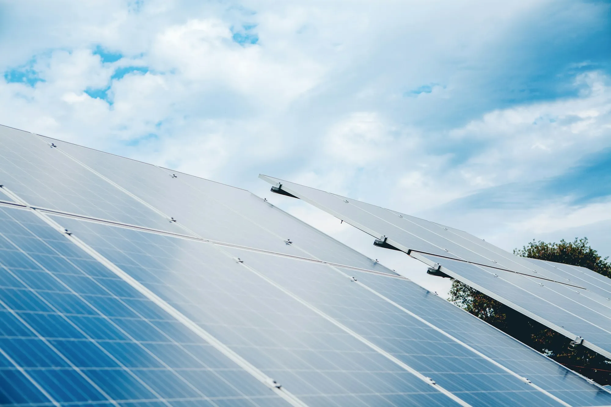 Rows of solar panels under a cloudy sky