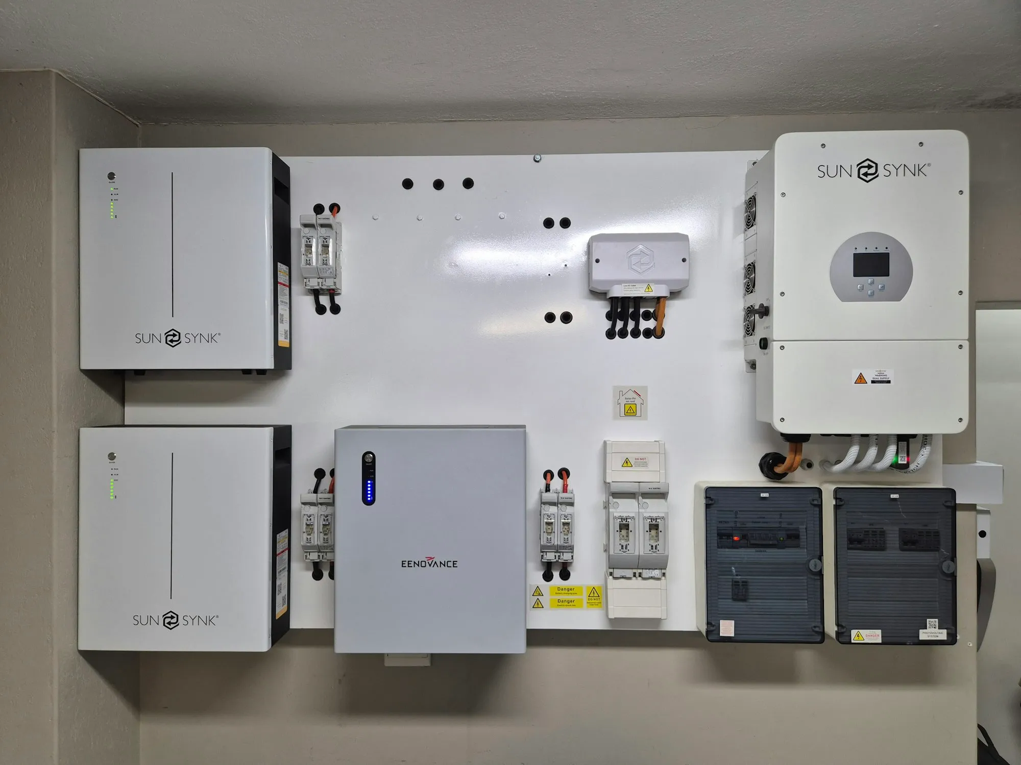 Wall-mounted battery storage and inverter units on a utility wall
